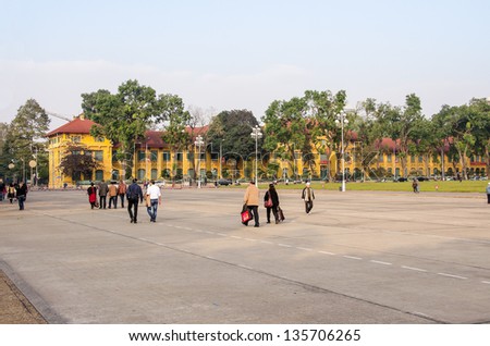 HANOI, VIETNAM - JANUARY 13: Unidentified people walk near the Ho Chi Minh complex - Ba Dinh square on January 13, 2013 in Hanoi. Central government offices of Vietnamese communist party on the right.