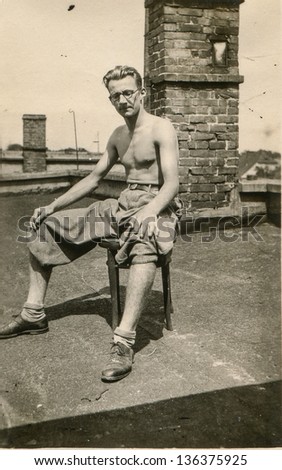 Vintage photo of man tanning on the roof, forties