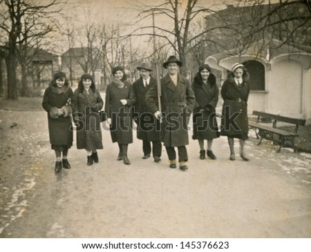 POLAND, CIRCA THIRTIES - vintage photo of group of men and women in coats and hats walking outdoor, Poland, circa thirties