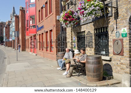 DUBLIN, IRELAND - JUNE 8: Family rests on bench in front of the oldest pub in Ireland,     The Brazen Head, Dublin, Ireland on June 8, 2013