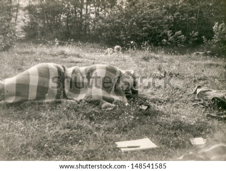Vintage photo of man sleeping outdoor, eighties