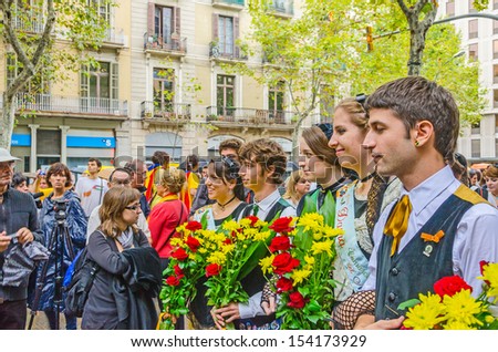 BARCELONA, SPAIN - SEPTEMBER 11: Unidentified Catalan youth offers flowers  to the monument of Rafael Casanova during the National Day of Catalonia, Barcelona, Spain on September 11, 2013