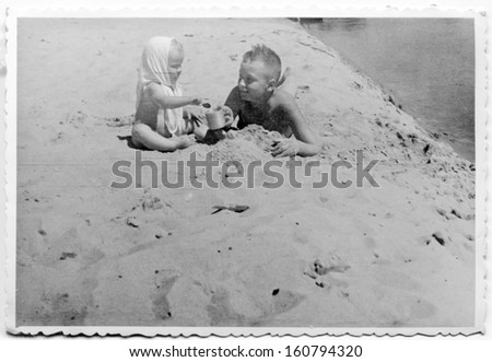Vintage photo of brother and little sister on beach - fifties