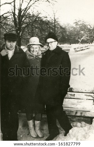 Vintage photo of mature parents with adult son in winter, sixties