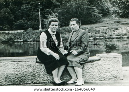LODZ, POLAND, CIRCA FIFTIES: vintage photo of two women sitting on wall, Lodz, Poland, circa fifties