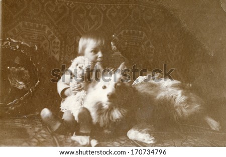 BIELSKO, POLAND, CIRCA FORTIES - vintage photo of baby with a dog and a doll