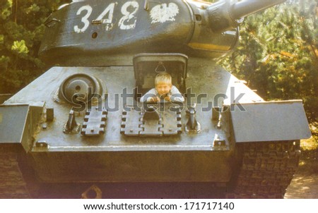 Vintage photo (scanned reversal film) of little boy in historical tank (early eighties)