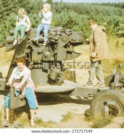 Vintage photo (scanned reversal film) of family visiting open air military museum, early eighties