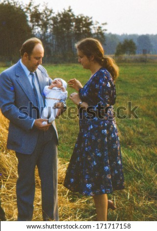 Vintage photo (scanned reversal film) of young parents with a baby boy (August 1982)
