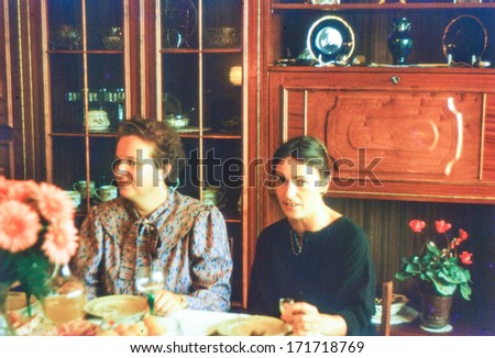 Vintage photo (scanned reversal film) of two women during a family dinner (early eighties)