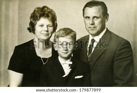 LODZ, POLAND, SEVENTIES - Vintage photo of little boy with his parents at his First Communion