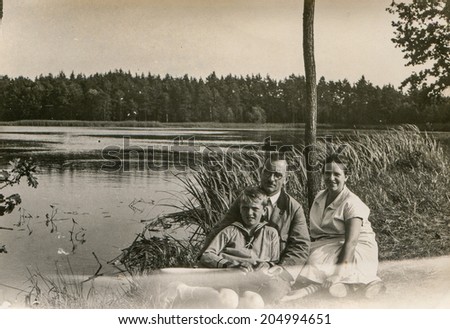 GERMANY, CIRCA THIRTIES - GERMANY, CIRCA THIRTIES - Vintage photo of parents and little son at lakeside