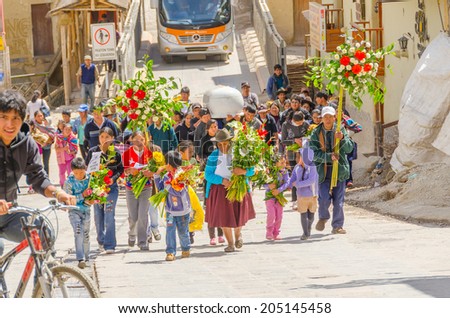 PERU, OLLANTAYTAMBO, MAY 4, 2014 -  Funeral procession of people carrying a white coffin and bunches of flowers heads to local cemetery