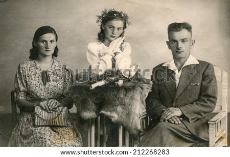 SIERADZ, POLAND, CIRCA FORTIES - Vintage photo of parents with their daughter at her First Communion