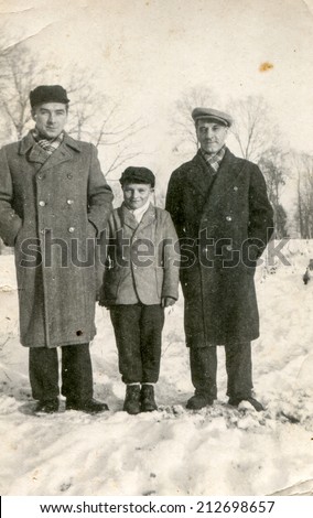 SIERADZ, POLAND - CIRCA FIFTIES: Vintage photo of grandfather, father and son outdoor in winter.