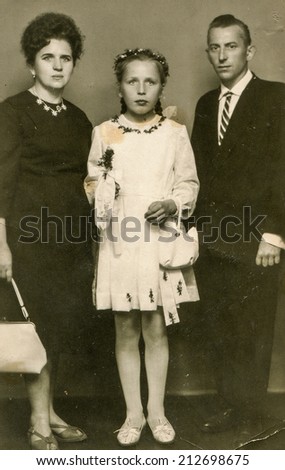 SIERADZ, POLAND - CIRCA 1960 - Vintage photo of parents with little girl at her First Communion.