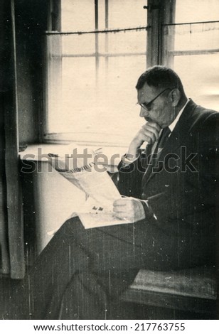 POLAND, CIRCA FIFTIES - Vintage photo of man reading a newspaper