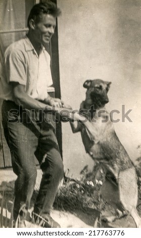 LODZ, POLAND, CIRCA FIFTIES - Vintage photo of man with a dog