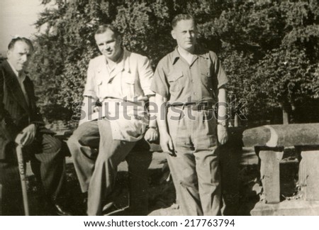 LODZ, POLAND, CIRCA FIFTIES - Vintage photo of three men in park