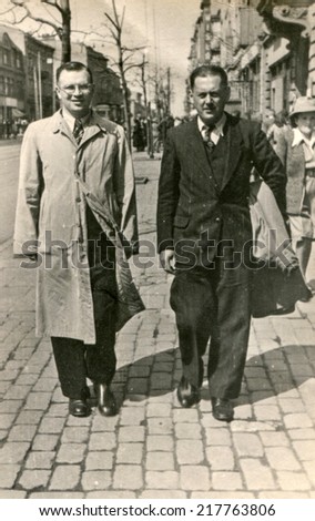 LODZ, POLAND, CIRCA FIFTIES - Vintage photo of two men walking down the street