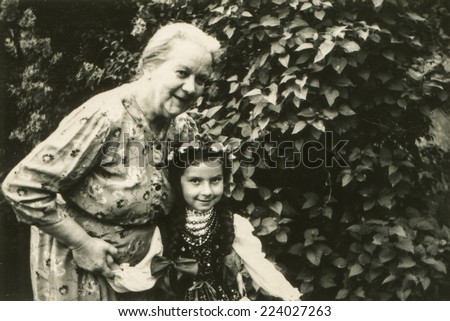 POLAND, CIRCA 1962: Vintage photo of grandmother with granddaughter in garden