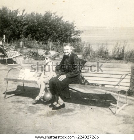 ANIELIN, POLAND, CIRCA FIFTIES: Vintage photo of grandmother with granddaughter on bench