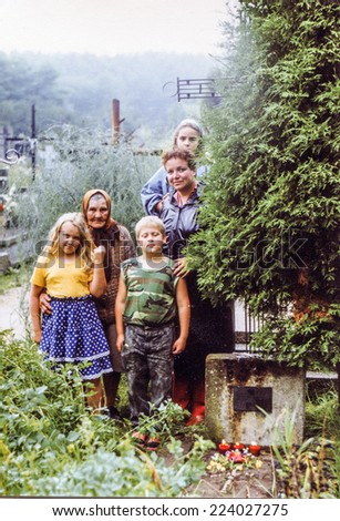 POLAND, CIRCA FIFTIES: Vintage photo of grandmother and mother with children on cemetery