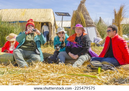 PUNO, PERU, MAY 5, 2014: Tourists watch a show of local craft at Uros Islands