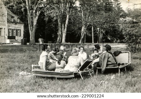 USTRONIE, POLAND, CIRCA SIXTIES: Vintage photo of group of people parting in garden