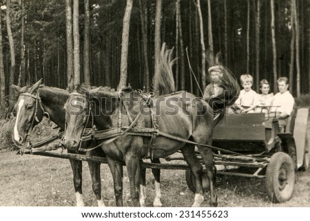 POLAND, CIRCA SIXTIES: Vintage photo of parents with little son traveling by horse-drawn carriage