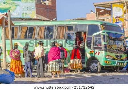 COPACABANA, BOLIVIA, MAY 6, 2014: Local people in traditional costumes get on the bus