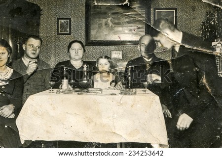 GERMANY, CIRCA 1930s:  Vintage photo of family sitting at table during Christmas
