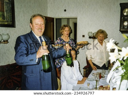 Vintage photo of family celebrating elderly couple\'s wedding anniversary, eighties