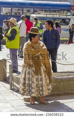 LA PAZ, BOLIVIA, MAY 8, 2014:   Local woman in traditional attire stays at Plaza San Francisco
