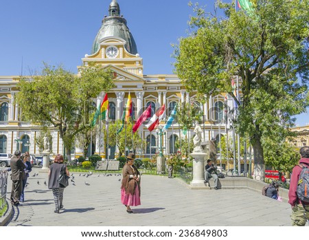 LA PAZ, BOLIVIA, MAY 8, 2014:  People walk at Plaza Murillo (Government Palace of Bolivia in background)