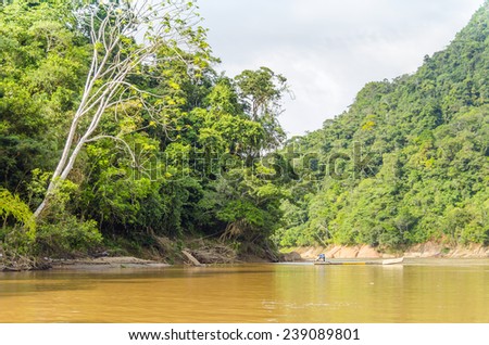 RURRENABAQUE, BOLIVIA, MAY 11, 2014: Local man travels in traditional wooden boat on Beni river
