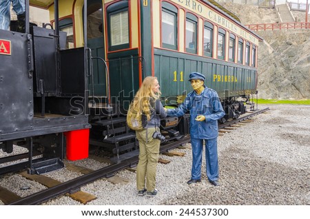 MOLLENDO, PERU, MAY 19, 2014:  female tourist shakes hands with a wax statue of rail worker in Ferro Carilles del Sur train open air museum