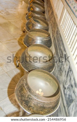 BANGKOK, THAILAND, DECEMBER 26, 2013: some of 108 bronze bowls indicating 108 auspicious characters of Buddha, Wat Pho temple