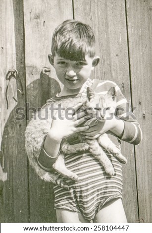 Vintage photo of little boy with a cat, 1950's