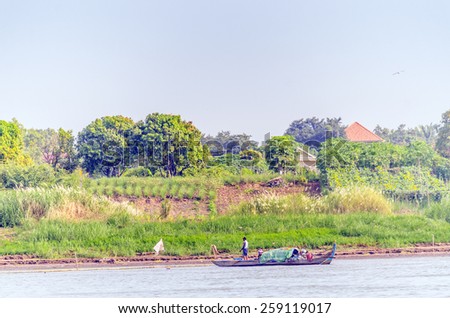 PHNOM PENH, CAMBODIA, JANUARY 2, 2013: Local people travel on fishing boat on Mekong river