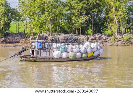 CHAU DOC, VIETNAM - JANUARY 2, 2013: Rural life in Mekong delta -Barge transports marchandise on Bassac River