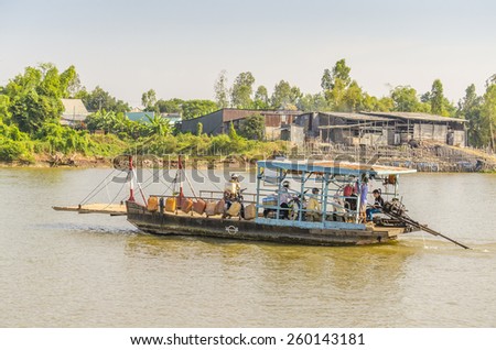 CHAU DOC, VIETNAM - JANUARY 2, 2013: Rural life in Mekong delta - Local people cross the Bassac River on small ferry boat