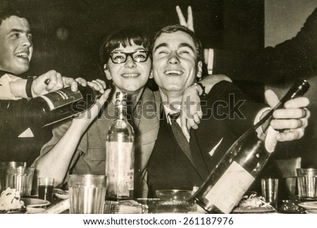 LODZ, POLAND, CIRCA 1960\'s: Vintage photo of young people having fun and drinking alcohol during a party