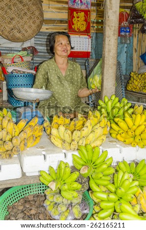 VINH LONG, VIETNAM, JANUARY 3, 2013: Local woman sells bananas at stall along the street in Vinh Long market
