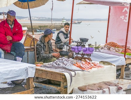 AS-SAWIRA, MOROCCO, APRIL 7, 2015: Fishermen sell fish and seafood in port of As-Sawira
