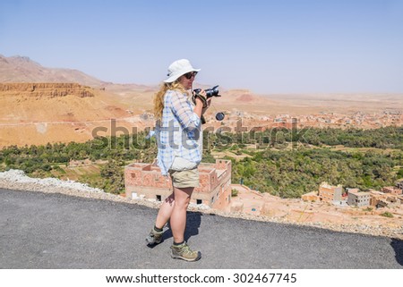 Female tourist taking pictures of Tinerhir - town near Todgha Gorge, Morocco
