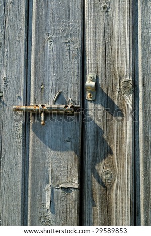 Old rusty handle on the wooden door