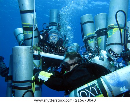 DAHAB, EGYPT - May 30, 1014: Support divers with Ahmed Gabr\'s empty tanks on the deco ladder during a 200 m training dive prior to his deepest scuba dive world record attempt in September 2014