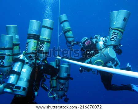DAHAB, EGYPT - May 30, 1014: Support divers with Ahmed Gabr's empty tanks on the deco ladder during a 200 m training dive prior to his deepest scuba dive world record attempt in September 2014