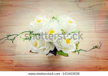 Beautiful fake flower on the wood table Process in vintage style picture)